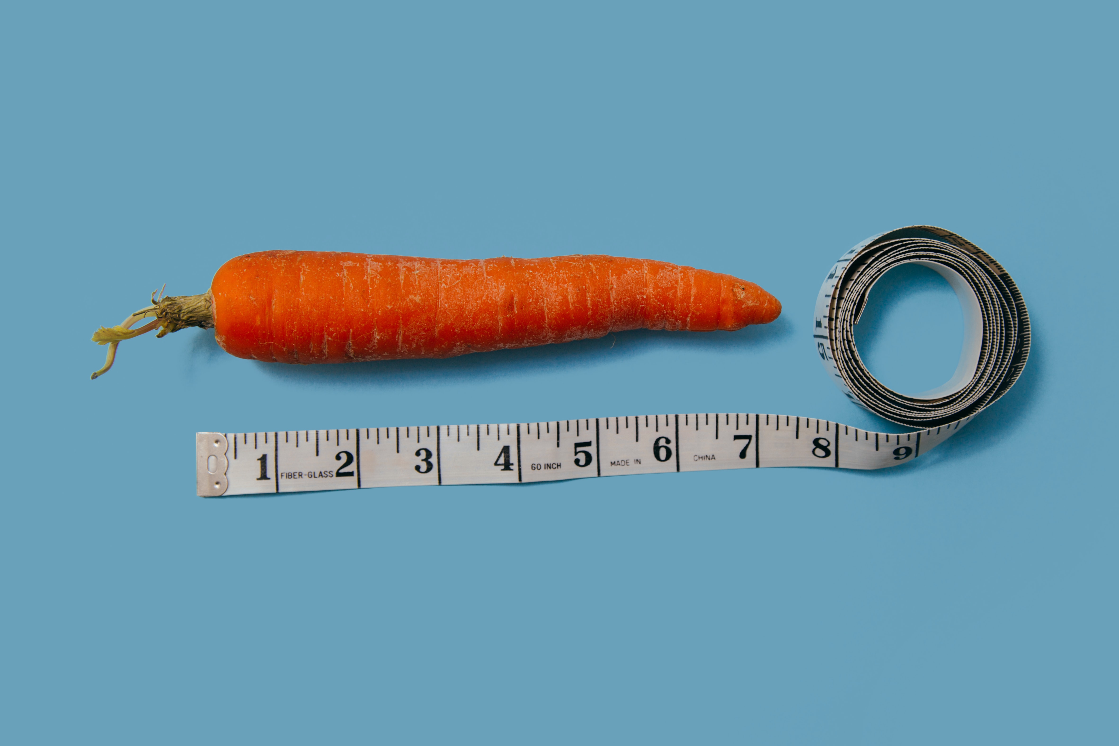 A carrot measured with a measuring tape as a metaphor for the research approach to how the bioeconomy in Europe should be measured.