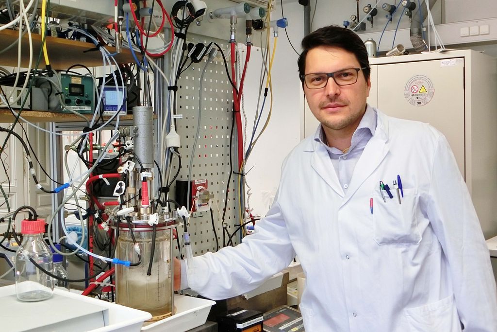 Stefan Pflügl im Labor. Links von ihm ein Bioreaktor. © TU Wien