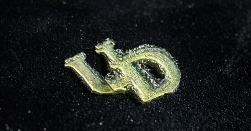 Photo of an interlocking UD created from 3D-printing resin made with technical lignin biomass. This is not a scratch-and-sniff photo, but, if it were, you might detect the slight smell of barbecue. The reason? The aromatic chemical compounds from the UD-developed process are akin to those found in liquid smoke. 