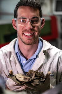 Rice graduate student Kevin Wyss holds a vial of graphene and samples of the graphene-reinforced polyurethane made by the Ford Motor Company.