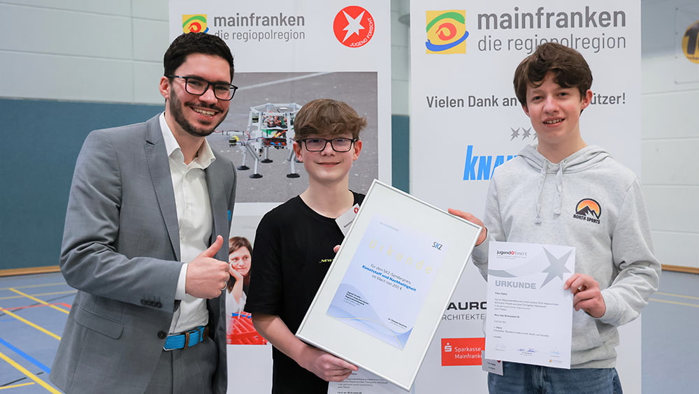 Matthias Ruff, Sales Manager Education & Research at SKZ, awards the special prize "Plastics and Sustainability" to Sebastian Völker and Timo Spatz for "Harzi - The Bioplastic" (from left to right) (Photo: Rudi Merkl).