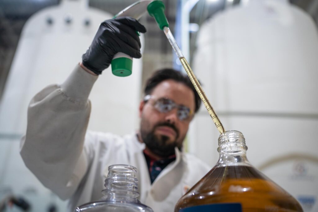 Picture of a scientist adding a liquid to a barrel