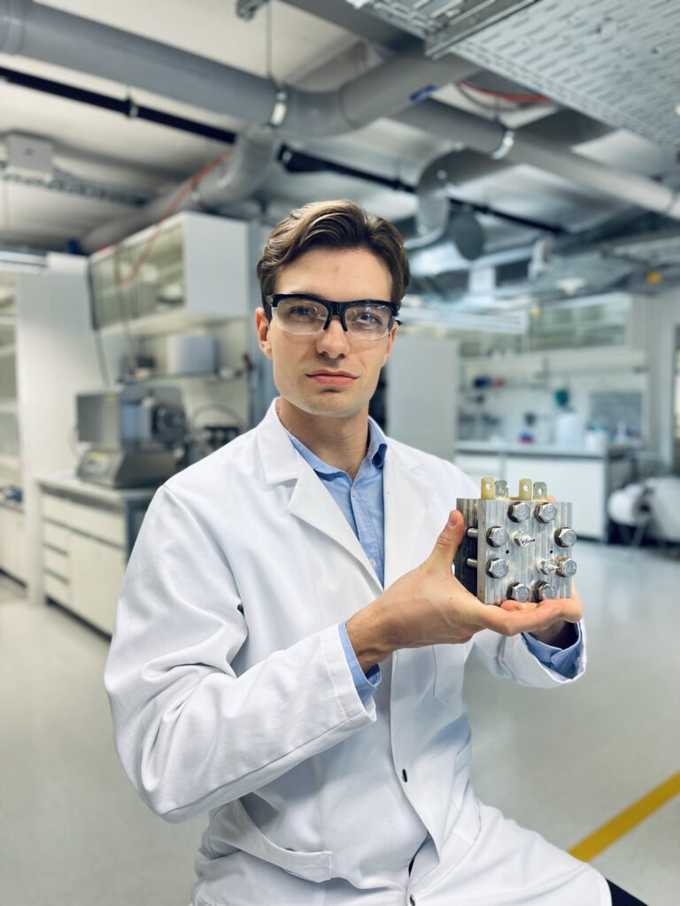 Cedric David Koolen showing an example electrochemical cell used in the Laboratory of Materials for Renewable Energy. 