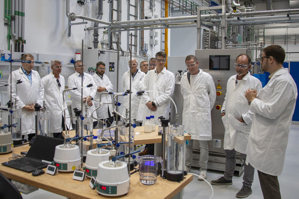 onas Massa (rechts), Geschäftsführers der AKROS Energy Gmbh, gibt in der Halle des LIKAT einen Einblick in die aktuelle Arbeit sowie einen Ausblick auf die Ziele des FormaPort-Projektes, die die vier Partner gemeinsam erreichen wollen.