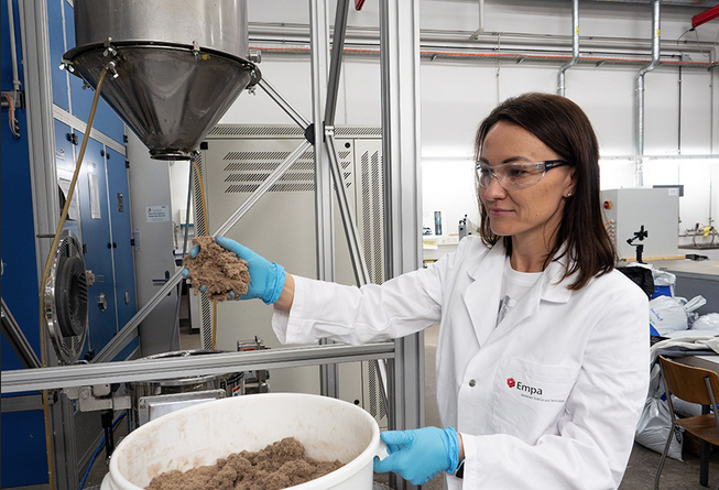 Empa researcher Yuliia Dudnyk with the flaky lignocellulose, the starting material for the circuit board.