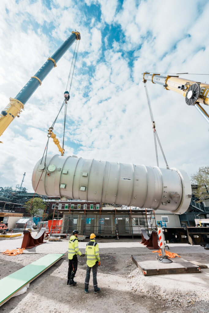 A heavyweight: Two cranes lift the nearly 100-ton falling-film evaporator into the air.