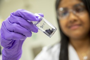 Lead researcher Aindrila Mukhopadhyay holds a vial of purified indigoidine powder. (Credit: Marilyn Chung/Berkeley Lab)