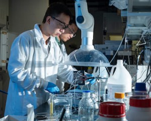 Rice postdoctoral researcher Chuan Xia, left, and chemical and biomolecular engineer Haotian Wang adjust their electrocatalysis reactor to produce liquid formic acid from carbon dioxide. Photo by Jeff Fitlow