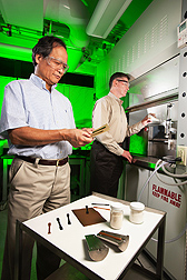Plant physiologist Arland Hotchkiss (right)<br />adds sugar beet pulp and polylactic acid to<br />an extruder to make the bioplastic strips that<br />chemist LinShu Liu is inspecting”></td>
</tr>
<tr>
<td style=